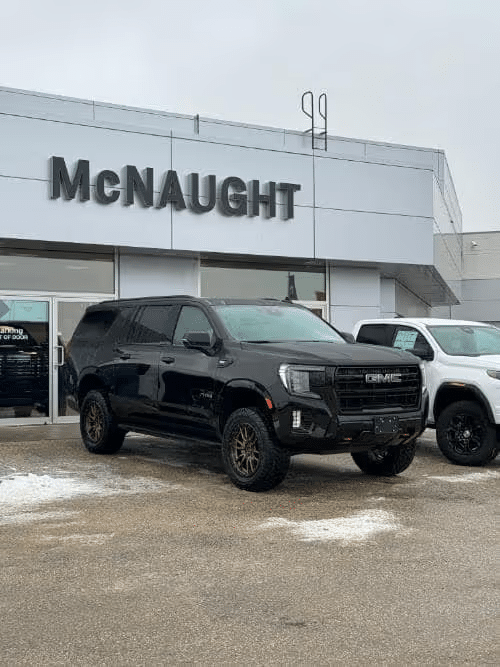 Black GMC SUV parked at McNaught dealership, showcasing sleek design and modern features.