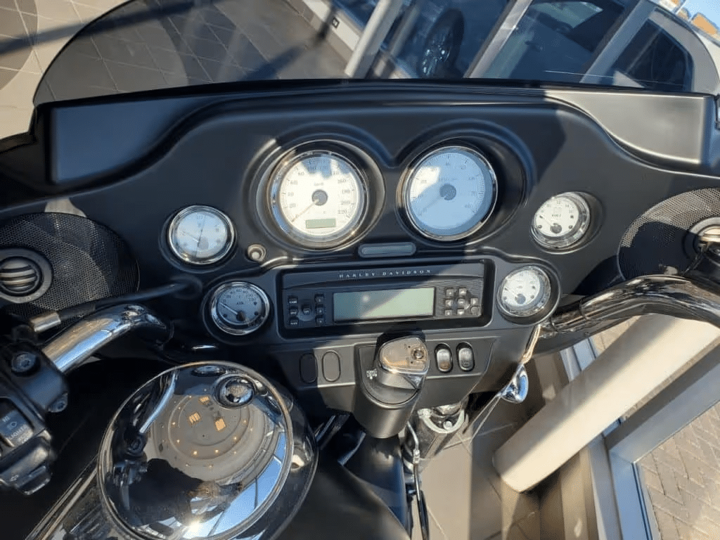 Close-up of a motorcycle dashboard showing speedometer and gauges, emphasizing detail and design.