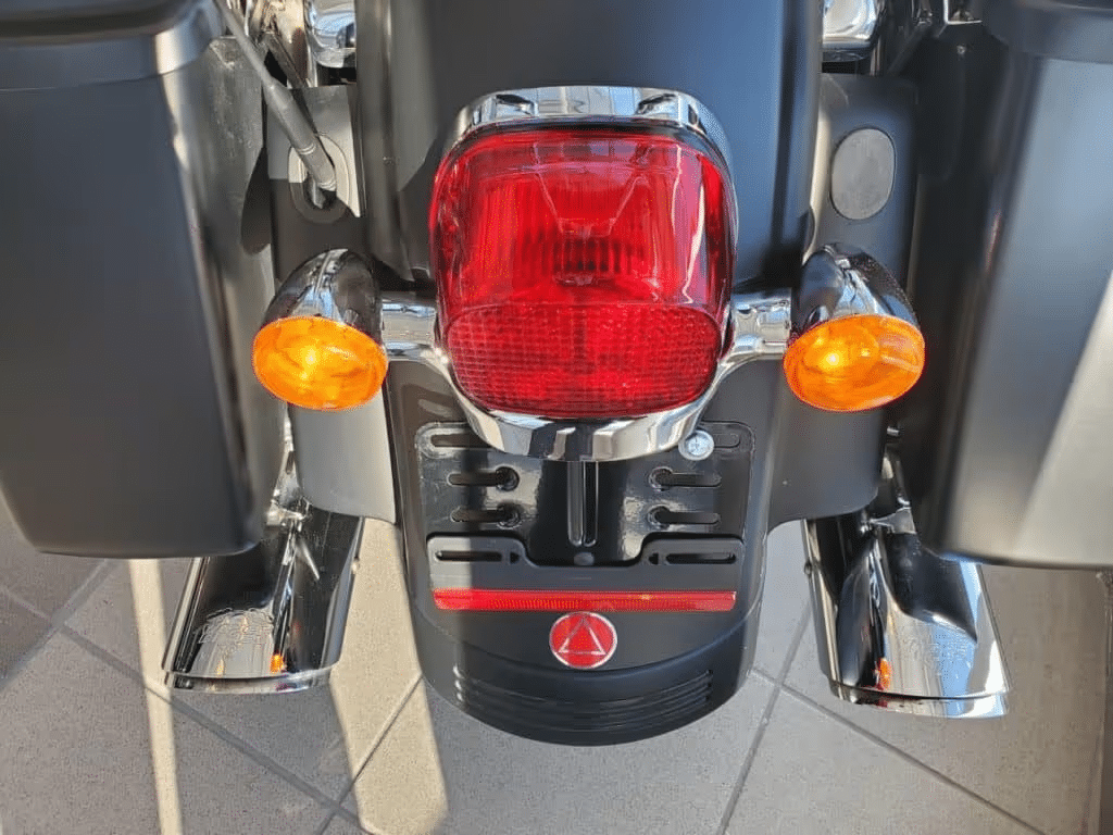 Motorcycle rear view showing chrome exhausts and brake lights.