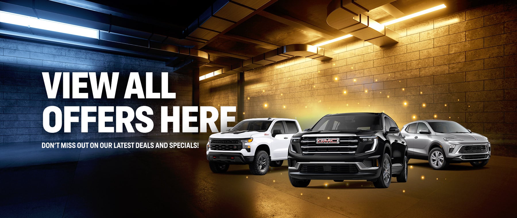 Three vehicles in a lit garage with text: "View All Offers Here. Don’t miss out on our latest deals and specials."