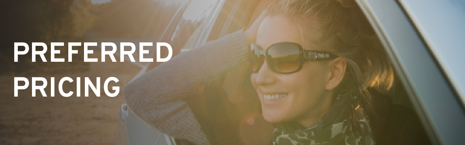 Smiling woman wearing sunglasses leans out car window with "Preferred Pricing" text overlay.