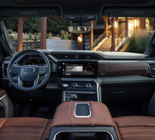 Luxury SUV interior with leather seats, digital dashboard, and wood accents, showcasing modern design.