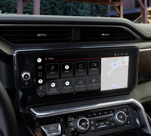 Car dashboard with touchscreen displaying navigation, apps, and controls in a modern vehicle interior.
