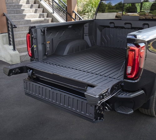 Pickup truck bed with a multi-functional tailgate in an open position.