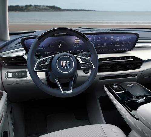 Luxurious car interior with digital dashboard, modern steering wheel, and beach view through the windshield.