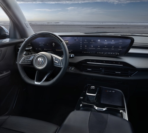 Modern car interior featuring a sleek dashboard with a digital display and a steering wheel, set against an ocean view.